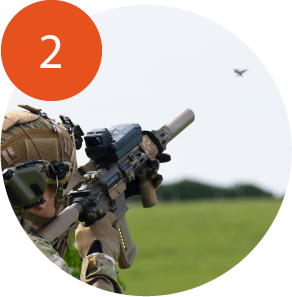 Soldier aiming SMASH system at drone